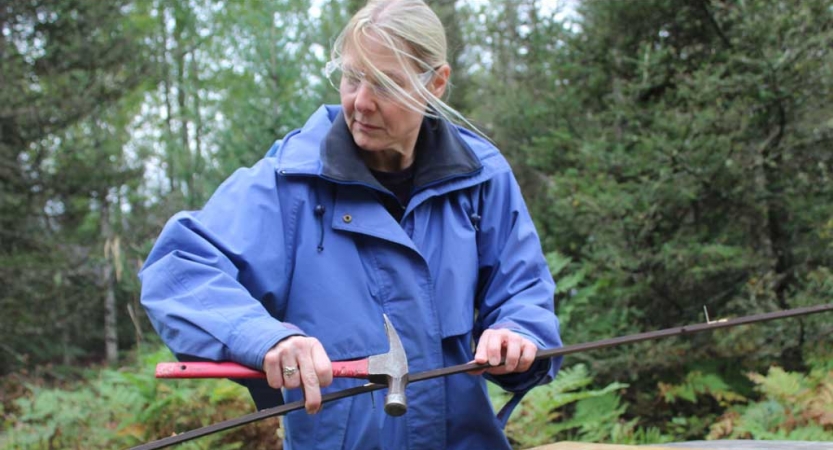 A person uses a hammer during a service project with Outward Bound.